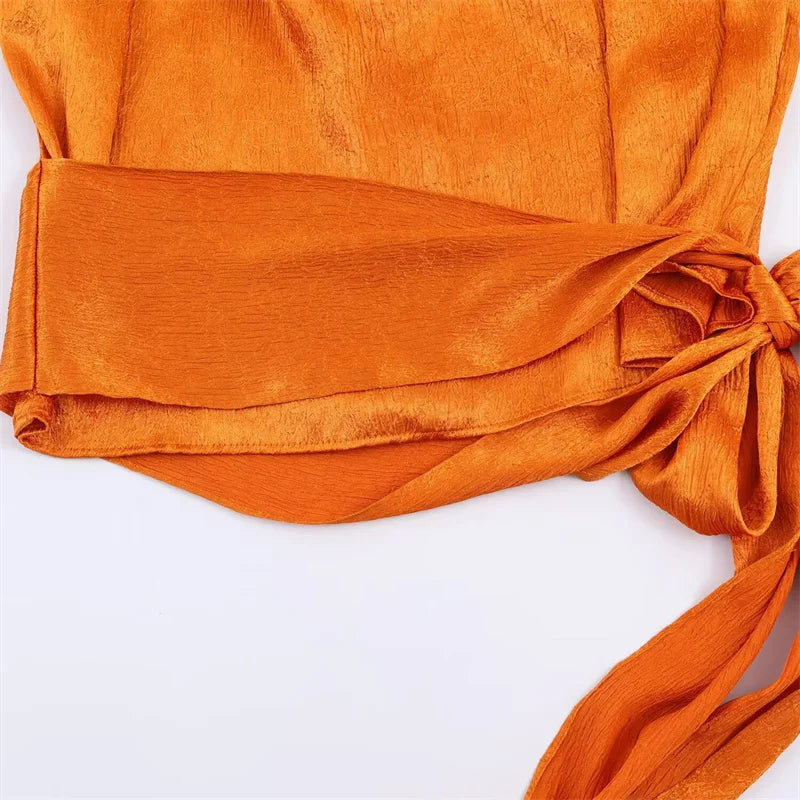 Top para mujer, novedad de primavera 2026: diseño naranja sin mangas con textura satinada y lazo largo; una prenda elegante, estilosa y única que marca tendencia.